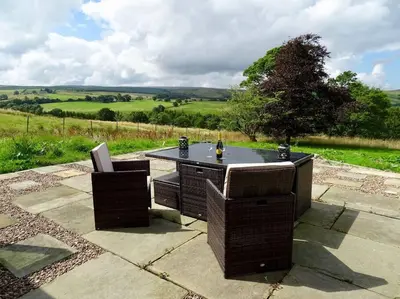 a table with two chairs and a bottle of wine at Swans Farm in Lancaster