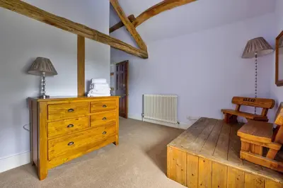 a room with a wooden dresser and a wooden bench at Swans Farm in Lancaster