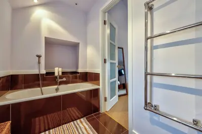 a bathroom with a bath tub next to a glass door at Swans Farm in Lancaster