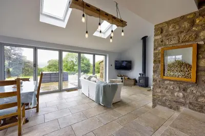 a living room with a couch and a stone wall at Swans Farm in Lancaster