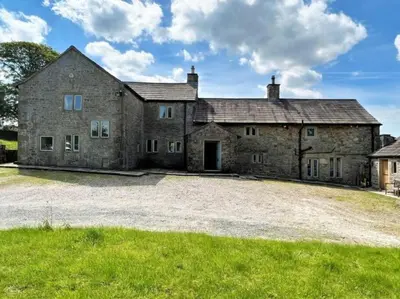 an old stone house with a large driveway at Swans Farm in Lancaster