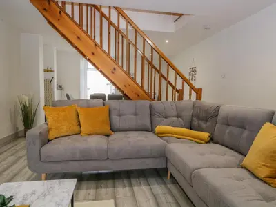 a living room with a gray couch with yellow pillows at Harbour Retreat in Millom