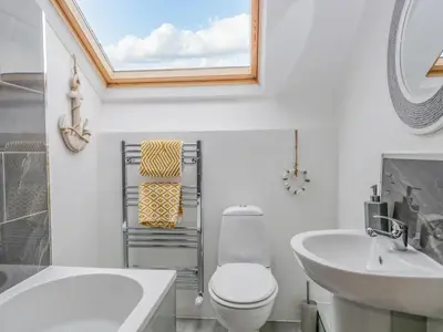 a bathroom with a toilet and a sink and a mirror at Harbour Retreat in Millom