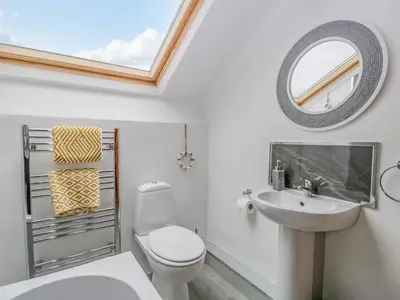 a bathroom with a toilet and a sink and a mirror at Harbour Retreat in Millom