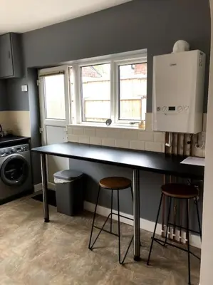 a kitchen with a counter and two stools in it at 2 Bedroom Bungalow in Mawdesley