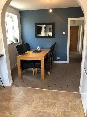 a dining room with a wooden table and black chairs at 2 Bedroom Bungalow in Mawdesley