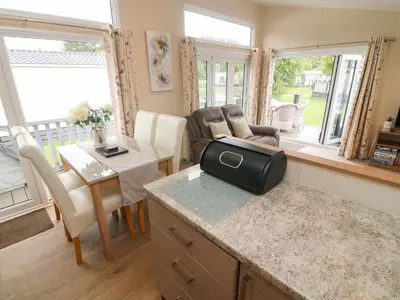 a living room with a kitchen and a living room with a table at Waterside Lodge in Carnforth