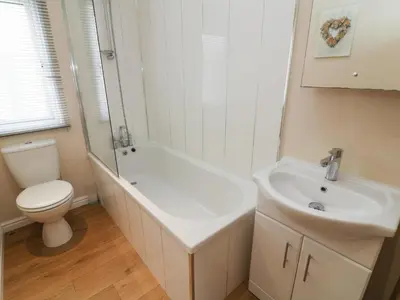 a white bathroom with a toilet and a sink at Waterside Lodge in Carnforth