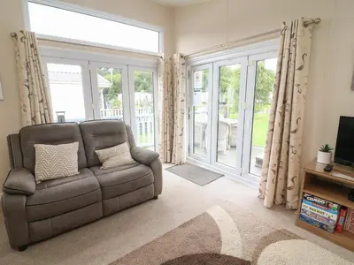 a living room with a couch and a large window at Waterside Lodge in Carnforth