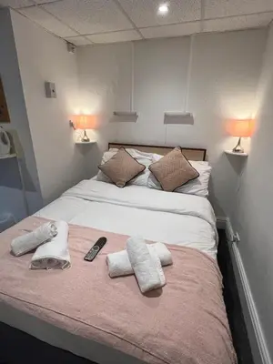 a bed with towels and a remote control on it at The Wilton Hotel in Blackpool