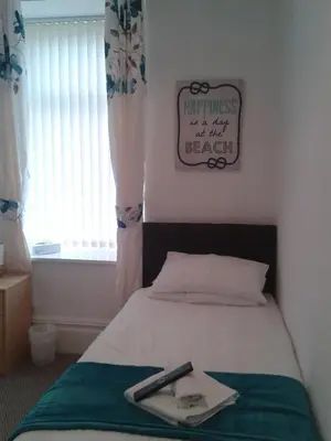 a bedroom with a bed with a remote control on it at The Wilton Hotel in Blackpool
