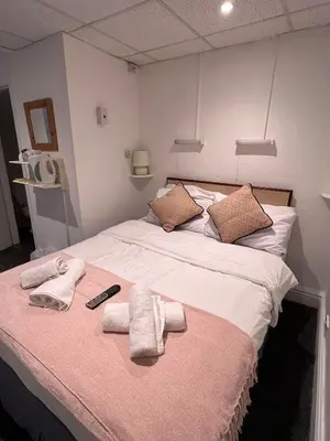 a bed with towels and a remote control on it at The Wilton Hotel in Blackpool