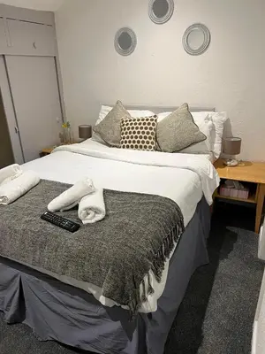a bedroom with a large bed with a remote control at The Wilton Hotel in Blackpool