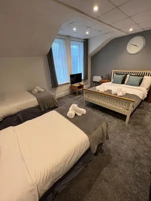 a hotel room with two beds and a television at The Wilton Hotel in Blackpool
