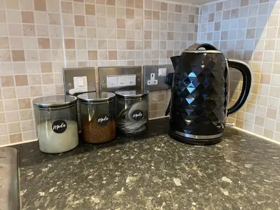 three trash cans sitting on a counter with a coffee maker at Moda Wigan - Stylish 2 Bed Apartment Central Wigan in Wigan