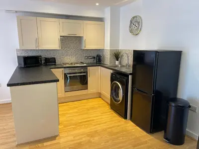 a kitchen with a black refrigerator and a dishwasher at Moda Wigan - Stylish 2 Bed Apartment Central Wigan in Wigan