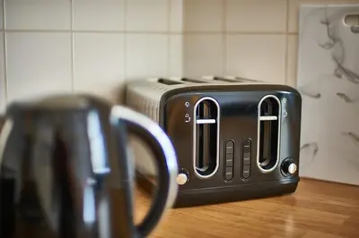 a black toaster sitting on top of a counter at The Little Bear Apartment Birkdale Village in Southport