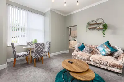 a living room with a couch and a table at Ashton Mews apartment with free parking in Saint Annes on the Sea