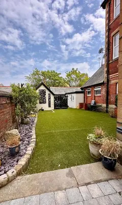 a yard of a house with a lawn with plants at Ashton Mews apartment with free parking in Saint Annes on the Sea