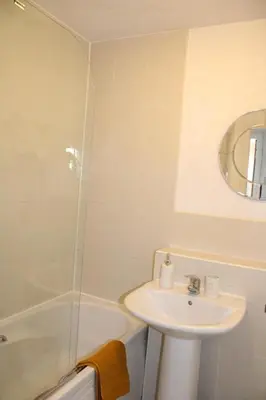 a white bathroom with a sink and a shower at Two Bedroom Apartment, Free parking, Close to UCLAN and free WIFI in Preston