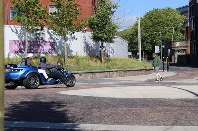 a couple of people riding a motorcycle down a street at Two Bedroom Apartment, Free parking, Close to UCLAN and free WIFI in Preston