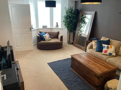 a living room with a couch and a coffee table at Cheerful Home FOR FOOTBALL, DOCKS AND CITY CENTRE in Liverpool
