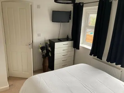 a bedroom with a bed and a dresser with a television at Cheerful Home FOR FOOTBALL, DOCKS AND CITY CENTRE in Liverpool