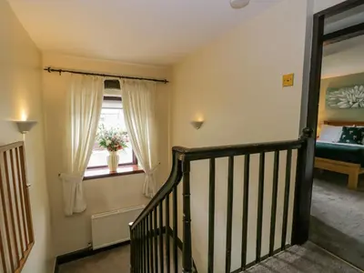 a stairway leading to a room with a window at Ewedale Farm in Ulverston