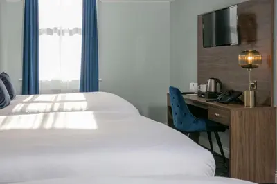 a hotel room with a bed and a desk with a television at Best Western Hotel 99 in Blackburn