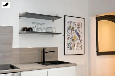 a kitchen with white cabinets and a sink and shelves at Blackbird Accommodation and Luxury Apartments room 12 in Blackpool