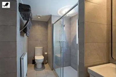 a bathroom with a toilet and a glass shower at Blackbird Accommodation and Luxury Apartments room 12 in Blackpool