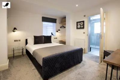 a bedroom with a king sized bed and a table at Blackbird Accommodation and Luxury Apartments room 12 in Blackpool
