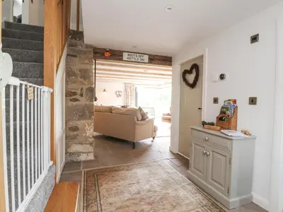 a living room with a couch and a staircase at Old Bell Works in Preston