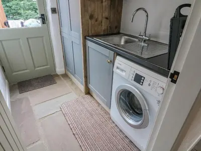 a kitchen with a washing machine and a sink at Old Bell Works in Preston