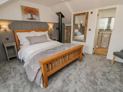 a bedroom with a large bed and a mirror at Old Bell Works in Preston