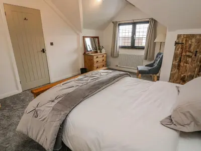 a bedroom with a large white bed and a chair at Old Bell Works in Preston