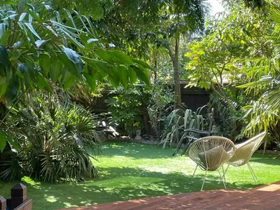 a garden with two chairs and a table in the grass at Luxury Oriental Home with Exotic Garden & Free Parking in West Derby