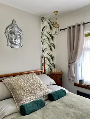 a bedroom with two beds and a mask on the wall at Luxury Oriental Home with Exotic Garden & Free Parking in West Derby