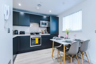 a kitchen with blue cabinets and a table with chairs at Bright, Luxury Aparthotel, Excellent Location in Liverpool