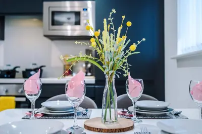 a table with a vase of flowers on a table at Bright, Luxury Aparthotel, Excellent Location in Liverpool