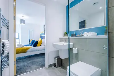 a bathroom with a toilet and a sink and a bed at Bright, Luxury Aparthotel, Excellent Location in Liverpool