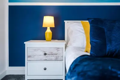 a bed with a night stand with a lamp on it at Bright, Luxury Aparthotel, Excellent Location in Liverpool