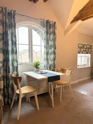 a table and chairs in a room with a window at Warehouse Apartment-1 King Bed Sleeps 2 in Ulverston