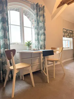 a desk and two chairs in a room with a window at Warehouse Apartment-1 King Bed Sleeps 2 in Ulverston