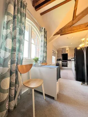 a kitchen with a table and a chair in a room at Warehouse Apartment-1 King Bed Sleeps 2 in Ulverston