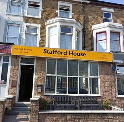a starford house with a yellow sign on a building at Stafford House in Blackpool