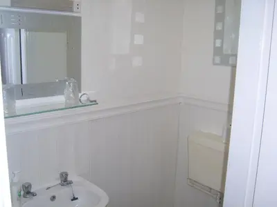 a white bathroom with a sink and a mirror at Stafford House in Blackpool