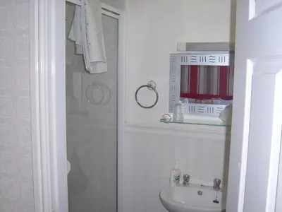 a white bathroom with a shower and a sink at Stafford House in Blackpool
