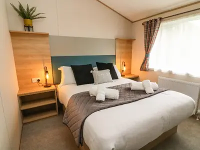 a bedroom with a large bed and a window at Barney's Retreat in Carnforth