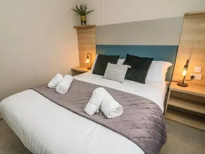 a bedroom with a large bed with towels on it at Barney's Retreat in Carnforth